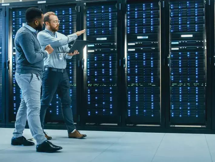 2men_walking_laptop_past_server_racks_2005_2600x1733.jpg copy